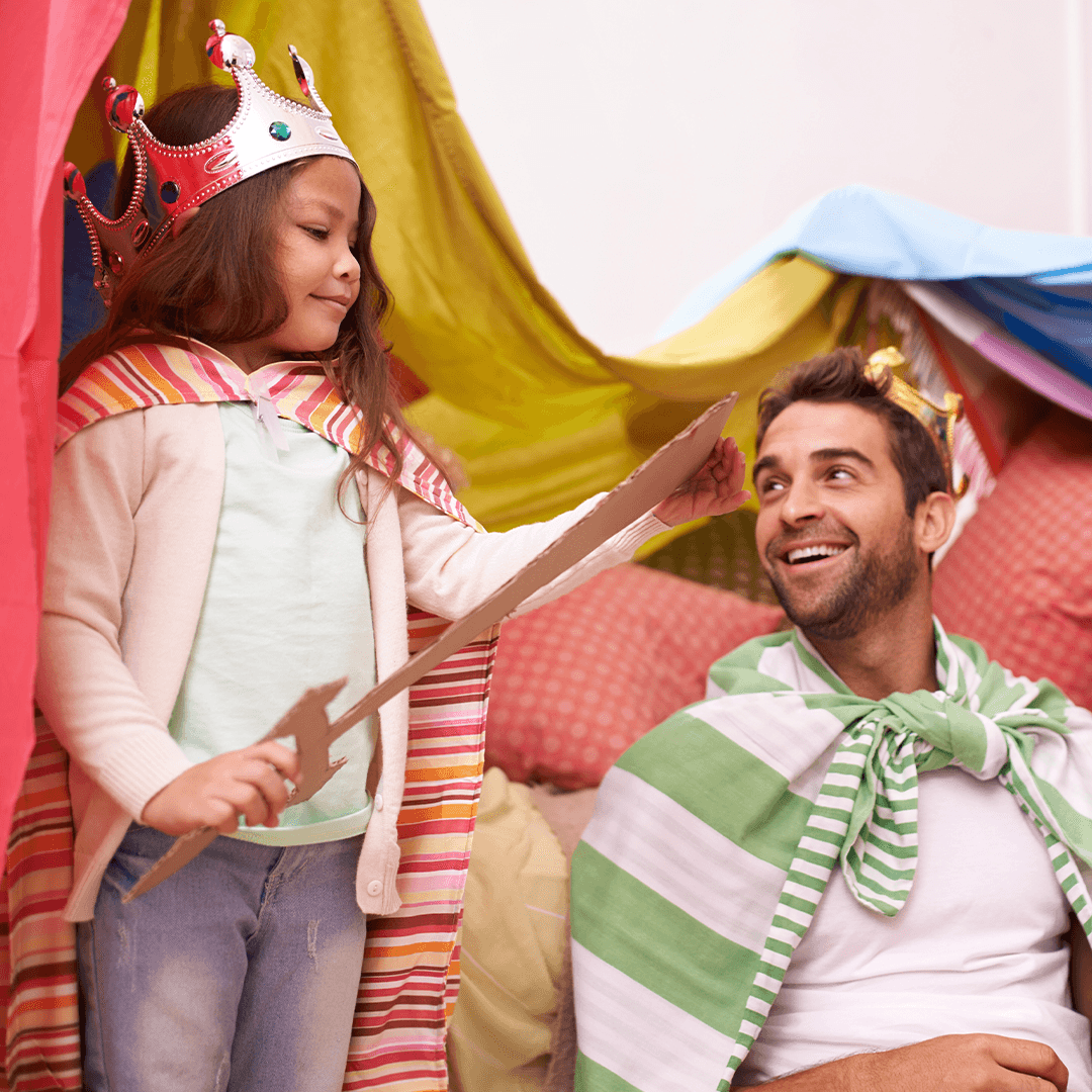 Father and daughter doing a homemade theater performance – imaginative indoor play for children.