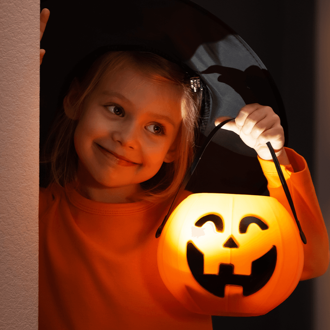 Mädchen hält eine Kürbislaterne an Halloween