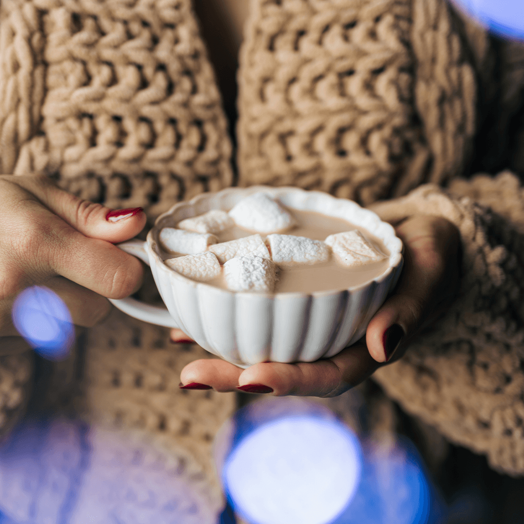 A woman enjoys a quiet moment with a cup of hot chocolate.