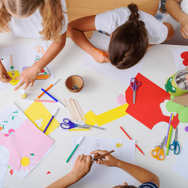 Kinder malen und basteln gemeinsam auf dem Boden